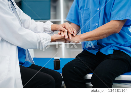 Asian doctor in white suit take notes while discussing and Asian elderly, man patient who lying on bed with receiving saline solution Asian doctor in white suit take notes while discussing and Asian elderly, man patient who lying on bed with receiving saline solution 134281164