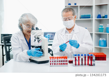 Doctor Talks With Professional Head Nurse or Surgeon, They Use Digital tablet Computer. Diverse Team of Health Care Specialists Discussing Test 134281173