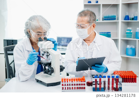 Doctor Talks With Professional Head Nurse or Surgeon, They Use Digital tablet Computer. Diverse Team of Health Care Specialists Discussing Test 134281178