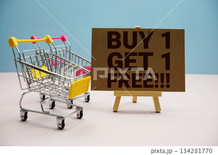 Buy 1 Get 1 Free!!! text with trolley shopping cart on pink background 134281770