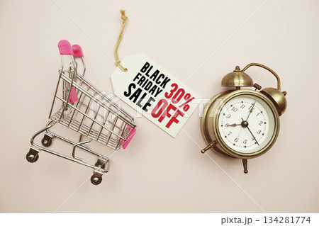 Black Friday Sale 30% off Limited time offer text with trolley shopping cart and alarm clock on pink background 134281774