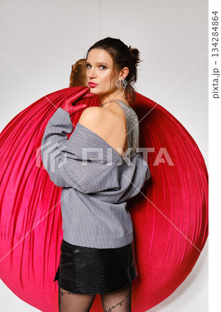 Model poses with red backdrop in fashion shoot at a studio 134284864