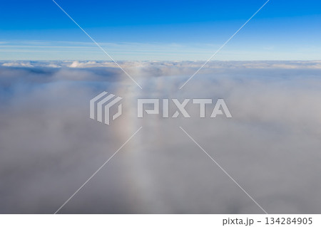 Soft clouds fill the frame as a vertical fogbow rises in daylight above Madeira near Pico do Arieiro. Minimalist composition and gentle light emphasize the rare effect. 134284905