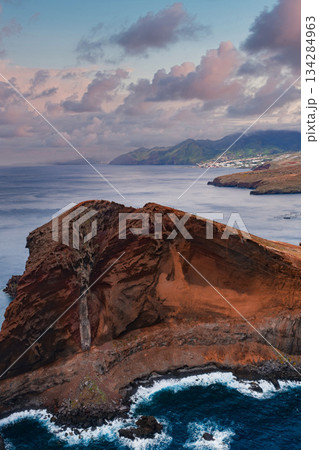 Aerial view of Ponta de Sao Lourenco on Madeira, Portugal, rust colored cliffs and waves, knife edge ridge and lava layers, evening light with distant mountains. Aerial view of Ponta de Sao Lourenco on Madeira, Portugal, rust colored cliffs and waves, knife edge ridge and lava layers, evening light with distant mountains. 134284963