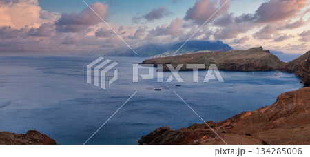 Reddish brown cliffs frame a calm Atlantic bay at Ponta de Sao Lourenco, Madeira, Portugal. Layered headlands and islets appear in soft evening light with long shadows. Reddish brown cliffs frame a calm Atlantic bay at Ponta de Sao Lourenco, Madeira, Portugal. Layered headlands and islets appear in soft evening light with long shadows. 134285006