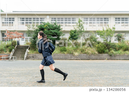 学校のグラウンドを走る通学・登校・下校する中学生・高校生・女子中学生・女子高生・女子高校生 134286056