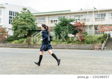 学校のグラウンドを走る通学・登校・下校する中学生・高校生・女子中学生・女子高生・女子高校生 134286057