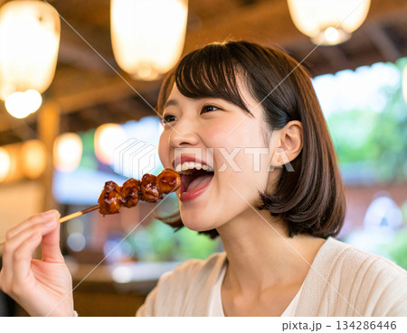 串焼きを食べる若い女性 134286446