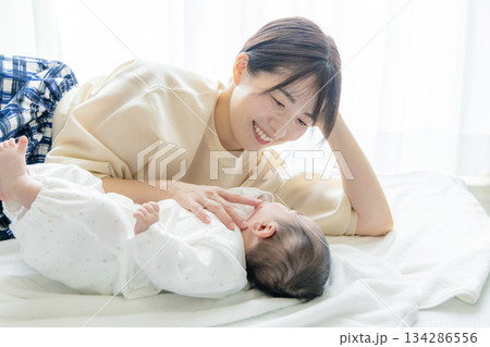 赤ちゃんの手を握るお母さん 赤ちゃんの手を握るお母さん 134286556