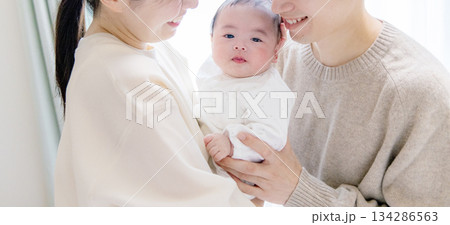 赤ちゃんを抱くファミリー 134286563
