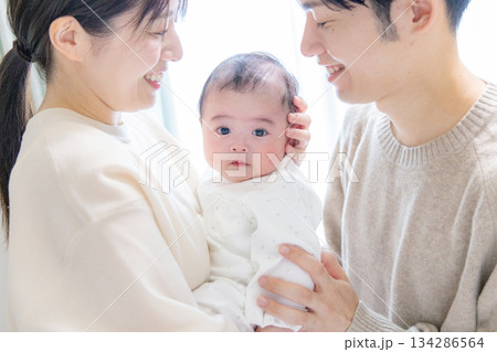 赤ちゃんを抱くファミリー 134286564