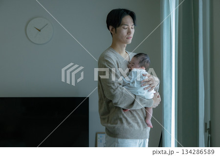 赤ちゃんを抱くお父さん　ネガティブ 134286589