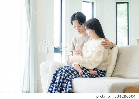 ソファーに座る夫婦と赤ちゃん 134286604
