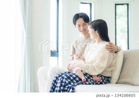 ソファーに座る夫婦と赤ちゃん 134286605