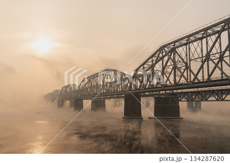Railway bridge in Krasnoyarsk over the foggy Siberian Yenisei River on a winter evening, Russia. Architecture of bridges in the rays of the setting sun. High quality photo Railway bridge in Krasnoyarsk over the foggy Siberian Yenisei River on a winter evening, Russia. Architecture of bridges in the rays of the setting sun. High quality photo 134287620