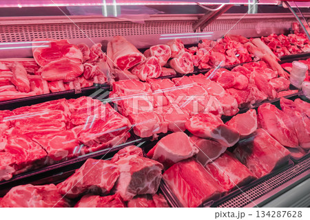 Chilled fresh meat, beef or pork fillet on a display case with red lighting. Meat merchandising at a local supplier's butcher shop. High quality photo 134287628