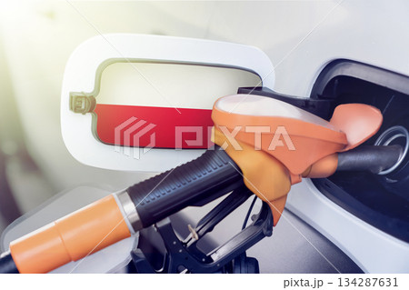 The Polish flag on the lid of the gas tank of a car at a gas station in close-up. High or low prices for gasoline and diesel fuel at Polish gas stations. shortage of fuel for cars in Poland. 134287631