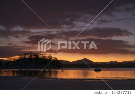 冬の朝焼けの湖とオレンジ色に染まる空 134287738