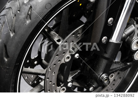 Detailed close-up view of a motorcycle front wheel, disc brake 134288092