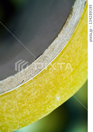 Yellow tape rolls on a work surface 134289195