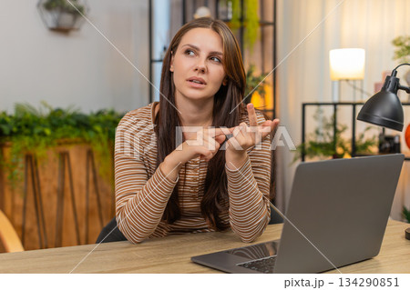 Young woman counts finished tasks on fingers folds digits reviews done list with calm focus indoors 134290851