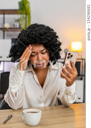 African American businesswoman upset sees bad news on smartphone after game loss reacts very shocked 134290881
