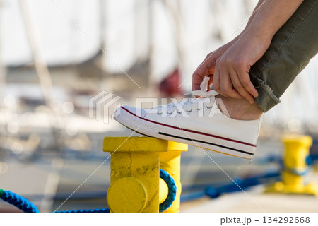 Woman tying shoes, white sneakers 134292668