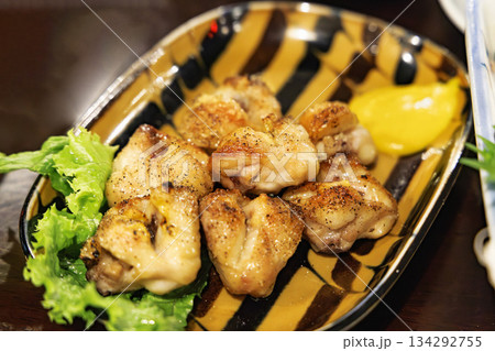 香ばしく焼き上げられた手羽先(鶏肉)とレモンのクローズアップ 香ばしく焼き上げられた手羽先(鶏肉)とレモンのクローズアップ 134292755