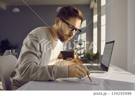 Professional cartographer working with printed cadastral map at table on his workplace. Professional cartographer working with printed cadastral map at table on his workplace. 134293896