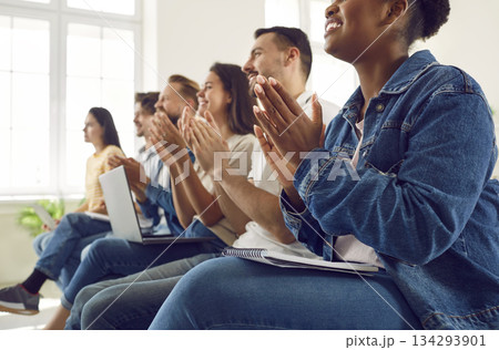Satisfied diverse audience of students or workers applauding during lecture or seminar. Satisfied diverse audience of students or workers applauding during lecture or seminar. 134293901