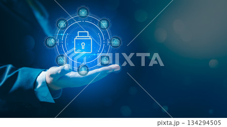 Business professional presenting glowing holographic lock and data icons, symbolizing cybersecurity, data protection, secure information management and advanced digital security technology solutions. Business professional presenting glowing holographic lock and data icons, symbolizing cybersecurity, data protection, secure information management and advanced digital security technology solutions. 134294505