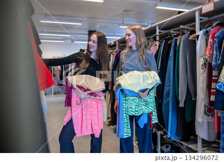 Women choosing clothes together in secondhand store 134296072