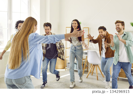 Group of happy, joyful, excited young people having a reunion with a good friend Group of happy, joyful, excited young people having a reunion with a good friend 134296915