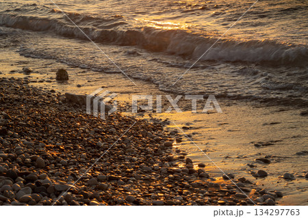 Pebbles and sea detail in the sunset, Greece 134297763