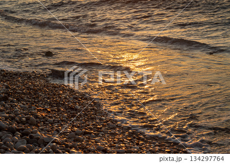 Pebbles and sea detail in the sunset, Greece 134297764