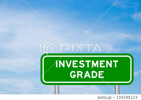 Green color transportation sign with word investment grade on blue sky with white cloud background 134298123
