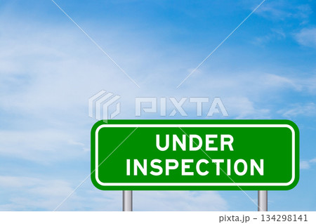 Green color transportation sign with word under inspection on blue sky with white cloud background Green color transportation sign with word under inspection on blue sky with white cloud background 134298141