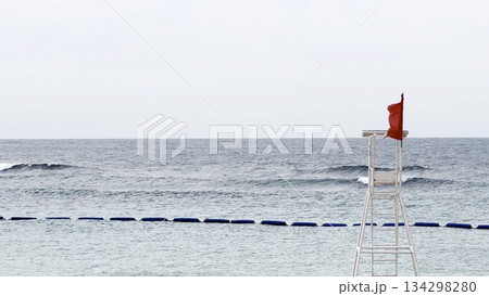 Red flag on lifeguard tower signals dangerous ocean conditions and swimming advisory 134298280