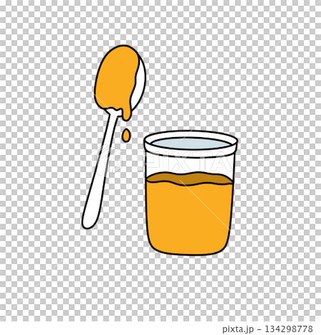 A spoon is in a glass of orange liquid 134298778
