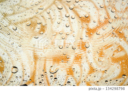 Abstract water droplets on glass with a swirling orange and white marble background texture. Abstract water droplets on glass with a swirling orange and white marble background texture. 134298798