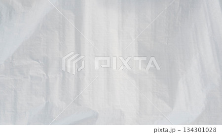 White plastic tarpaulin texture with subtle folds and wrinkles, minimal abstract background. White plastic tarpaulin texture with subtle folds and wrinkles, minimal abstract background. 134301028