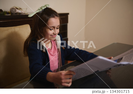 Young Girl Reading A Magazine At Home Table With A Hair Comb Young Girl Reading A Magazine At Home Table With A Hair Comb 134301715