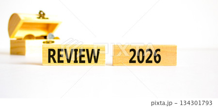 Review 2026 symbol. Concept words Review 2026 on beautiful wooden blocks. Beautiful white paper background. Beautiful wooden chest with coins. Business and review 2026 concept. Copy space. 134301793