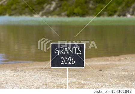Grants 2026 symbol. Concept words Grants 2026 on beautiful black blackboard. Beautiful mountain lake sand beach background. Business and grants 2026 concept. Copy space. 134301848