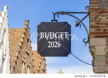 Budget 2026 symbol. Concept words Budget 2026 on beautiful black road sign. Beautiful street and buildings in Brugge blue sky background. Business and budget 2026 concept. Copy space. 134301879