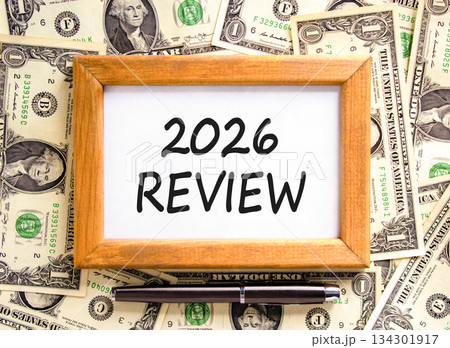 2026 Review symbol. Concept words 2026 Review on beautiful wooden picture frame. Beautiful dollar bills background. Black pen. Dollar bills. Business and 2026 review concept. Copy space. 134301917