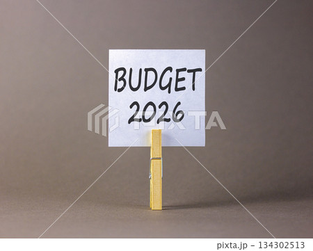 Budget 2026 symbol. Concept words Budget 2026 on beautiful white paper on wooden clothespin. Beautiful grey background. Business and budget 2026 concept. Copy space. Budget 2026 symbol. Concept words Budget 2026 on beautiful white paper on wooden clothespin. Beautiful grey background. Business and budget 2026 concept. Copy space. 134302513