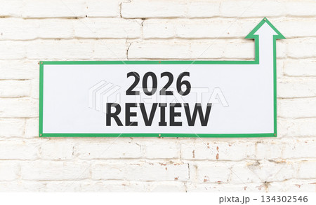 2026 Review symbol. Concept words 2026 Review on beautiful white sign with arrow. Beautiful old white brick wall background. Business and 2026 review concept. Copy space. 2026 Review symbol. Concept words 2026 Review on beautiful white sign with arrow. Beautiful old white brick wall background. Business and 2026 review concept. Copy space. 134302546