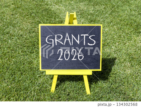 Grants 2026 symbol. Concept words Grants 2026 on beautiful black blackboard. Beautiful green grass background. Business and grants 2026 concept. Copy space. 134302568