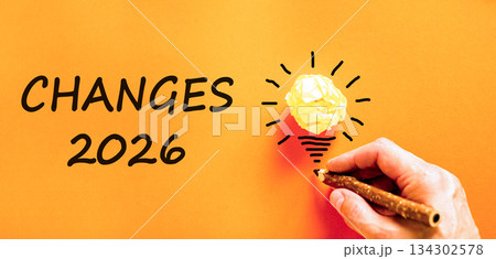 Changes 2026 symbol. Concept words Changes 2026 on beautiful orange paper. Beautiful orange paper background. Light bulb icon. Businessman's hand with pen. Business changes 2026 concept. Copy space Changes 2026 symbol. Concept words Changes 2026 on beautiful orange paper. Beautiful orange paper background. Light bulb icon. Businessman's hand with pen. Business changes 2026 concept. Copy space 134302578